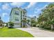 Beautiful two-story house with a concrete driveway, lush green lawn, and inviting exterior design in a coastal setting at 191 Grackle Ln., Pawleys Island, SC 29585