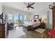 Bright main bedroom with hardwood floors, ceiling fan, balcony access, and a decorative rug at 191 Grackle Ln., Pawleys Island, SC 29585