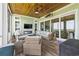 Inviting screened-in porch features a fireplace, TV, and comfortable wicker furniture for relaxing and entertaining at 191 Grackle Ln., Pawleys Island, SC 29585