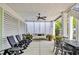 Covered patio with rocking chairs, ceiling fan, and a charming porch swing with privacy curtains at 191 Grackle Ln., Pawleys Island, SC 29585