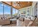 Cozy screened porch with comfortable seating, wood ceiling and a fireplace creating an inviting outdoor living space at 191 Grackle Ln., Pawleys Island, SC 29585