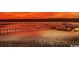 Picturesque sunset view of a long wooden pier stretching across tranquil marsh waters at 1980 Bent Grass Dr. # F, Surfside Beach, SC 29575