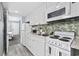 Compact kitchen featuring white cabinets, granite countertops, and appliances for convenient cooking at 2001 S Ocean Blvd. # 815, Myrtle Beach, SC 29577
