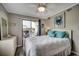 Relaxing bedroom with a ceiling fan, white bed, and access to a private balcony at 211 N Hillside Dr. # 204, North Myrtle Beach, SC 29582