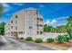 Attractive condo building with white fencing, landscaping, and exterior staircases and balconies at 211 N Hillside Dr. # 204, North Myrtle Beach, SC 29582