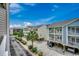 Street-level exterior view of colorful townhomes with tropical landscaping at 211 N Hillside Dr. # 204, North Myrtle Beach, SC 29582