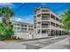 Coastal condos featuring white railings, ground-level parking, palm trees, and a beautiful blue sky at 211 N Hillside Dr. # 204, North Myrtle Beach, SC 29582