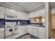 Cozy kitchen with white cabinets, blue backsplash, and modern appliances at 211 N Hillside Dr. # 204, North Myrtle Beach, SC 29582