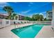 Community pool surrounded by lounge chairs and palm trees, perfect for relaxation and enjoying the summer at 211 N Hillside Dr. # 204, North Myrtle Beach, SC 29582