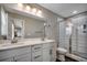 The updated bathroom boasts a double vanity, a large mirror, and a tiled shower enclosure at 211B 15Th Ave. S, Surfside Beach, SC 29575