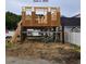 Under-construction home showing its initial framing with beams and wooden supports on a sandy lot at 211B 15Th Ave. S, Surfside Beach, SC 29575