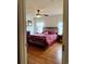 Comfortable bedroom boasts a decorative iron bed frame, ceiling fan, and bright natural lighting at 216 Walden Lake Rd., Conway, SC 29526