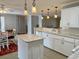 Well-lit kitchen with an island, white cabinets, granite countertops, and updated appliances for a modern appeal at 216 Walden Lake Rd., Conway, SC 29526