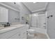 Well-lit bathroom featuring a vanity with solid surface countertops and a tub with sliding glass doors at 24 Jerry Ct., Pawleys Island, SC 29585