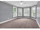 Bright bedroom featuring plush carpeting, a ceiling fan, and large bay windows with blinds at 24 Jerry Ct., Pawleys Island, SC 29585
