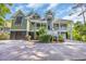 Two-story home featuring a spacious porch, landscaped front yard and multi-car garage underneath at 24 Jerry Ct., Pawleys Island, SC 29585