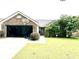 Well-maintained single-story brick home, featuring a lush lawn, front yard tree, and garage at 2707 Canvasback Trail, Myrtle Beach, SC 29588