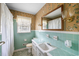 Classic bathroom featuring turquoise tile, floral wallpaper, and a large mirror at 316 Oliver St., Marion, SC 29571