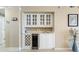 Elegant bar area with glass-front cabinets, a built-in wine cooler, and decorative accents at 341 South Dunes Dr. # C-34, Pawleys Island, SC 29585