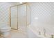 Bathroom with a bathtub and shower combo, toilet, and patterned wallpaper at 341 South Dunes Dr. # C-34, Pawleys Island, SC 29585