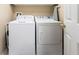 Efficient laundry area equipped with a washing machine, dryer, and overhead storage at 341 South Dunes Dr. # C-34, Pawleys Island, SC 29585
