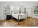 Bright bedroom with a brass bed frame, hardwood floors, and white wall paneling at 346 Tuckers Rd. # A, Pawleys Island, SC 29585