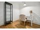 Stylish home office space featuring glass cabinet, white desk and accent chair on wood floor at 346 Tuckers Rd. # A, Pawleys Island, SC 29585