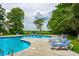 Inviting outdoor pool with ample seating and lush green surroundings, perfect for relaxation at 346 Tuckers Rd. # A, Pawleys Island, SC 29585