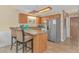 Kitchen with wood cabinets, breakfast bar, stainless steel refrigerator, and neutral tile flooring at 3700 Golf Colony Lane # 20-L, Little River, SC 29566