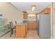 Open kitchen with breakfast bar, stainless refrigerator, and wood cabinetry, flowing into living space at 3700 Golf Colony Lane # 20-L, Little River, SC 29566