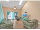 Bright living room with vaulted ceilings, skylights, ceiling fan, and sliding door access to balcony at 3700 Golf Colony Lane # 20-L, Little River, SC 29566