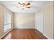 A standard empty bedroom features wood floors, white trim, a window and a ceiling fan at 403 75Th Ave N # C, Myrtle Beach, SC 29572