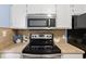 A well-equipped kitchen features stainless steel appliances and sleek black cooktop at 403 75Th Ave N # C, Myrtle Beach, SC 29572