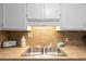 Kitchen sink features tiled countertops and backsplash at 403 75Th Ave N # C, Myrtle Beach, SC 29572