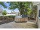 Relaxing backyard featuring a wooden deck with a hot tub, surrounded by trees and greenery at 4196 Ravenwood Dr., Little River, SC 29566