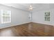 Bright bedroom featuring wood floors and two windows with blinds at 4196 Ravenwood Dr., Little River, SC 29566
