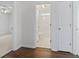 Hallway view transitions to bathroom with all-white features, complemented by hardwood floors in the hallway at 4196 Ravenwood Dr., Little River, SC 29566