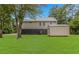 A spacious backyard with green grass, an exterior storage shed, and a view of the home at 4600 Murrells Inlet Rd., Murrells Inlet, SC 29576
