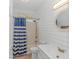 Bright bathroom featuring a white vanity, shower-tub combo, and nautical striped shower curtain at 4600 Murrells Inlet Rd., Murrells Inlet, SC 29576