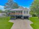 Exterior of home featuring covered parking, a wood porch, and an American flag at 4600 Murrells Inlet Rd., Murrells Inlet, SC 29576