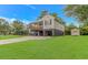 Side view of a coastal-style home with a wooden porch and a lush green lawn at 4600 Murrells Inlet Rd., Murrells Inlet, SC 29576