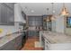 A modern kitchen with stainless steel appliances, gray cabinets, and a large marble island at 4600 Murrells Inlet Rd., Murrells Inlet, SC 29576