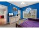 Bright blue bedroom with an exterior door, window, and dresser at 4673 Wild Iris Dr. # 21-201, Myrtle Beach, SC 29577