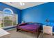 Cozy bedroom with bright blue walls, a wooden bed frame, and large window at 4673 Wild Iris Dr. # 21-201, Myrtle Beach, SC 29577