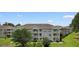 Attractive condo building with three stories and multiple balconies overlooking a lawn at 4673 Wild Iris Dr. # 21-201, Myrtle Beach, SC 29577