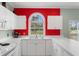 Bright kitchen featuring a stainless steel sink and bright red accent wall at 4673 Wild Iris Dr. # 21-201, Myrtle Beach, SC 29577