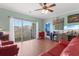 Bright living room featuring a ceiling fan, red furniture, and a sliding glass door to the outdoor patio at 4673 Wild Iris Dr. # 21-201, Myrtle Beach, SC 29577