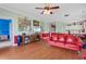 Open-concept living room featuring a television, red couch, and seamless transitions to other living spaces at 4673 Wild Iris Dr. # 21-201, Myrtle Beach, SC 29577