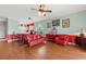 Spacious living room with red furniture, opening to the kitchen with an island and bar seating at 4673 Wild Iris Dr. # 21-201, Myrtle Beach, SC 29577