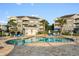 Outdoor pool area with lounge chairs, palm trees, and nearby buildings at 4673 Wild Iris Dr. # 21-201, Myrtle Beach, SC 29577